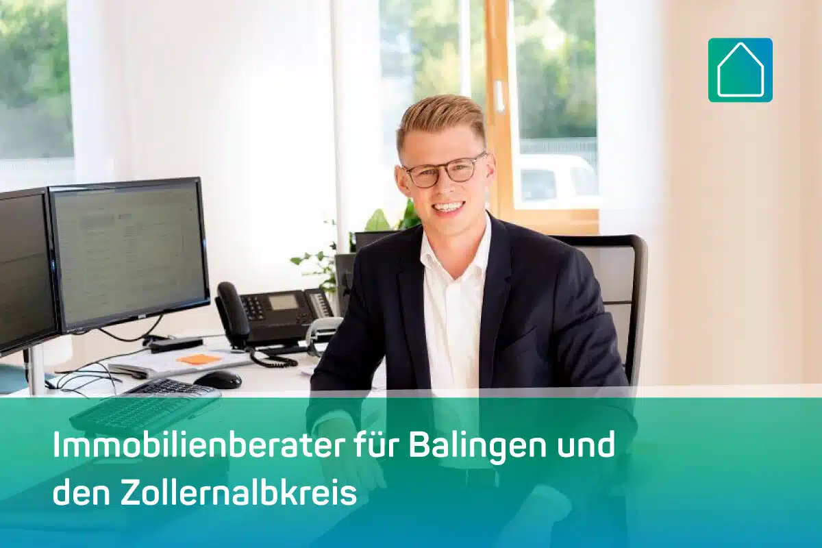 Ein lächelnder Mann im Anzug sitzt an einem Schreibtisch mit Computermonitoren in einem hellen Büro. Der Text lautet: Immobilienberater für Balingen und den Zollernalbkreis, mit einem Logo in der Ecke.